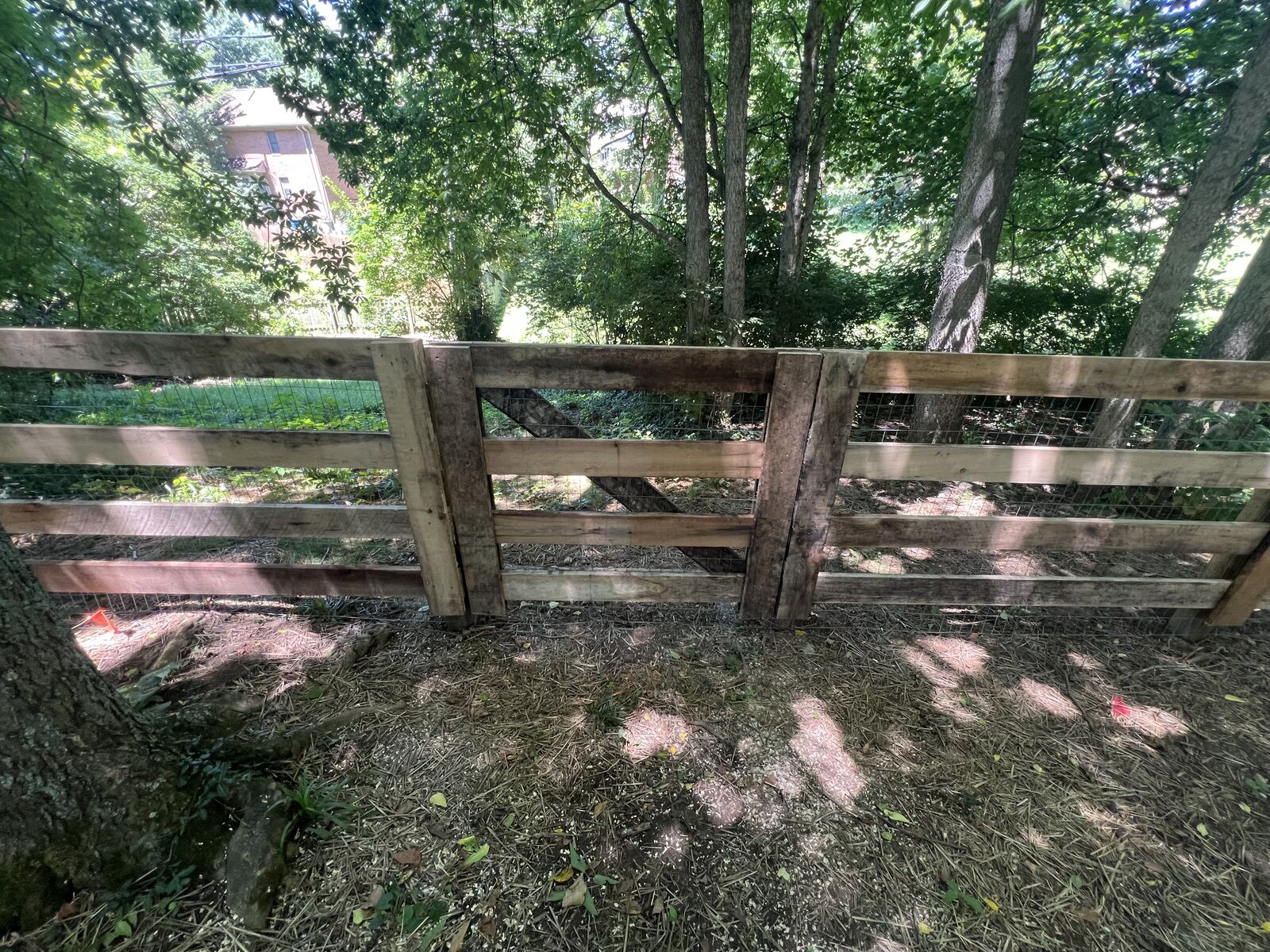 Rustic wood board fence along a wooded lot