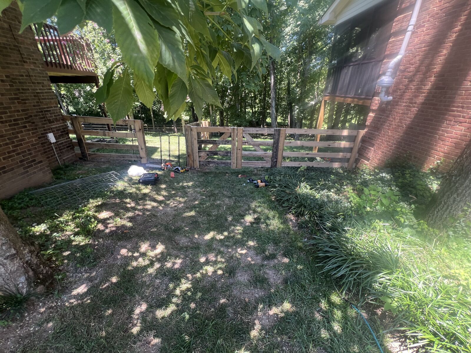 Wood board fence and gate between two brick houses