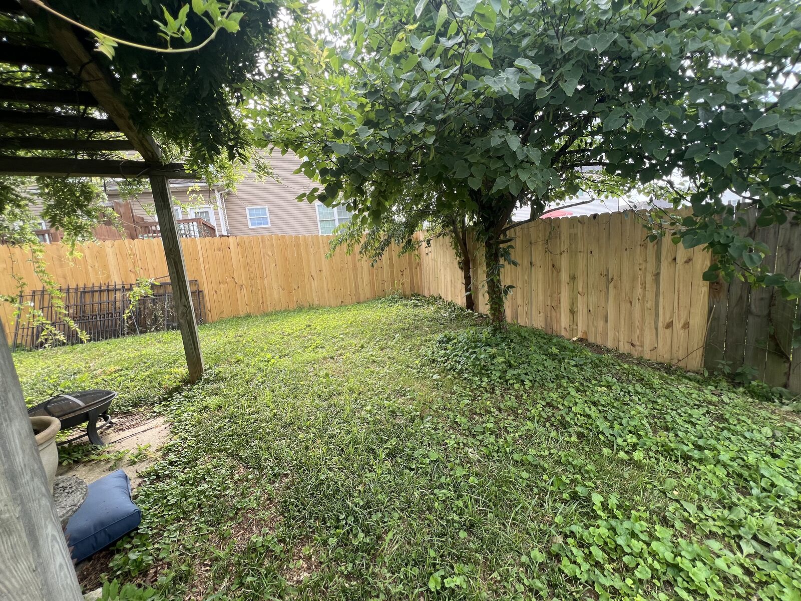 Wood privacy fence surrounding a shaded backyard