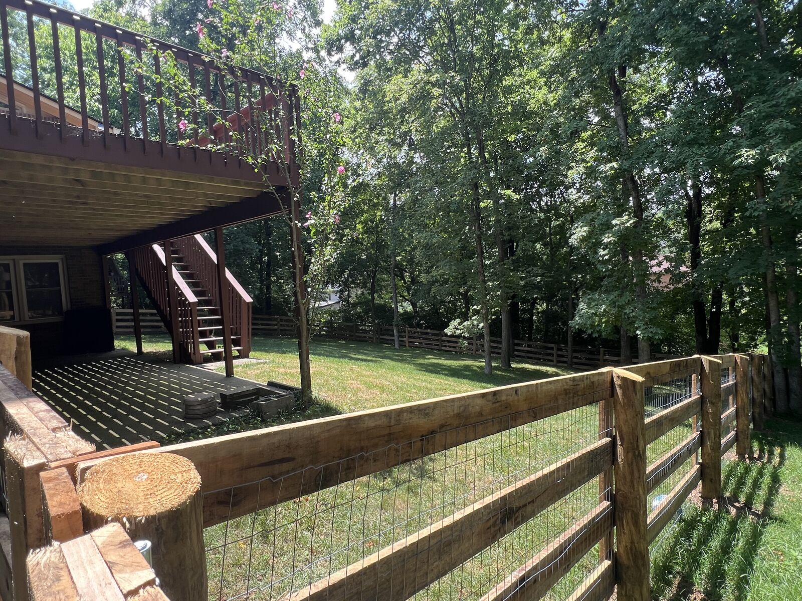 Wood board fence with wire mesh beneath a back deck